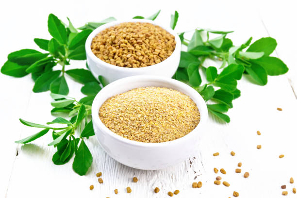 istock Fenugreek in two bowls with leaves on white board 1299405822