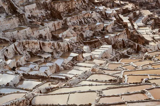Photo of Salt ponds of Maras in the Sacred Valley of the Incas, close to Urubamba, a popular tourist travel destination near Cuzco and Machu Picchu in Peru. Basins for salt production of salt industry
