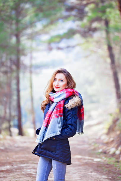 istock Young woman walking away alone on a forest path 1299409676