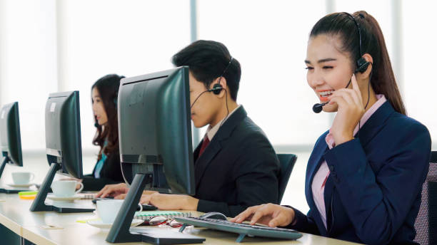 istock Business people wearing headset working in office 1299410571