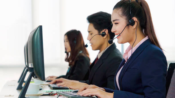 istock Business people wearing headset working in office 1299410614