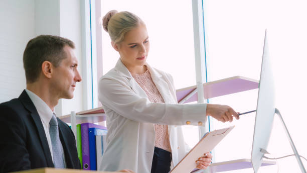 istock Two business people talk project strategy at office 1299410715