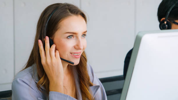 istock Business people wearing headset working in office 1299410822