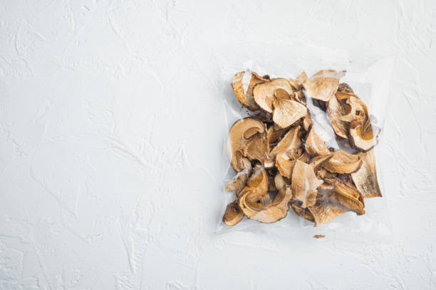 istock Dried mushrooms, on white background, in plastic pack, top view flat lay , with space for text  copyspace 1299410850