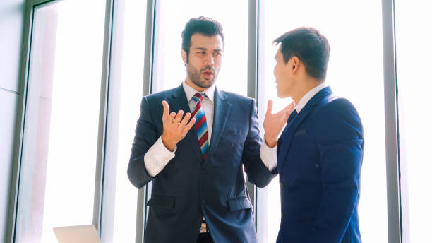 istock Two business people talk project strategy at office 1299410973