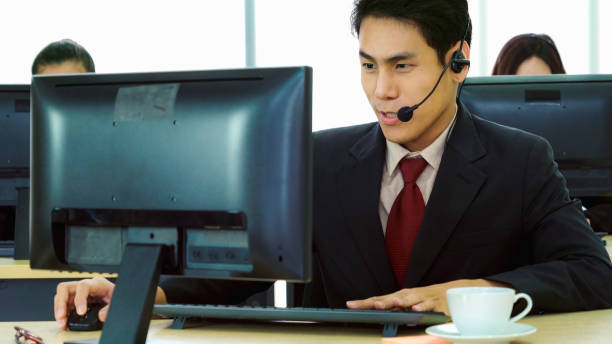 istock Business people wearing headset working in office 1299411588