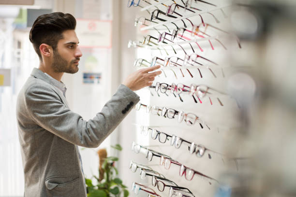 Man in office looking some glasses in optical store
