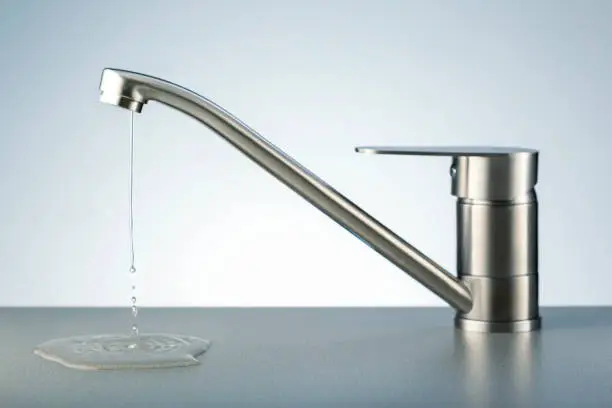 Damaged leaking water tap. Water leaking, saving concept.