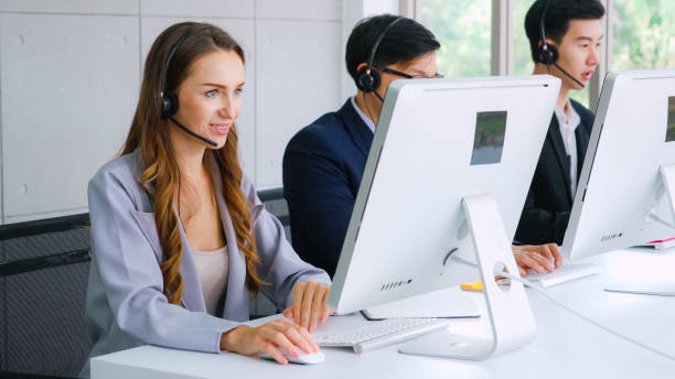 istock Business people wearing headset working in office 1299412127