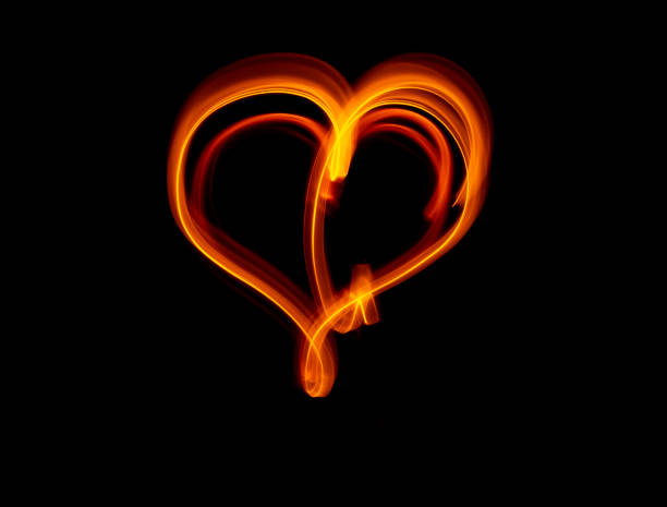 istock Light wave trail path, vibrant neon gold color in abstract swirls on a black background 1299416384