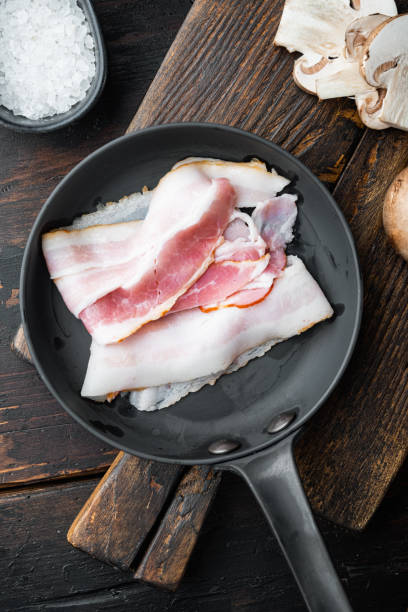 istock Fresh cold sliced bacon, on old dark  wooden table background, top view flat lay 1299417419