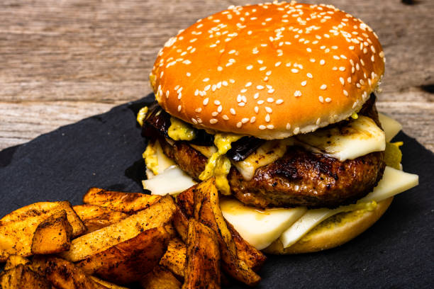 Homemade fresh tasty cheese burger and fried potatoes on a wooden table Homemade fresh tasty cheese burger and fried potatoes on a wooden table 8564 stock pictures, royalty-free photos & images