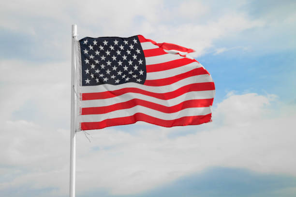istock American flag on a blue sky with clouds background 1299421401