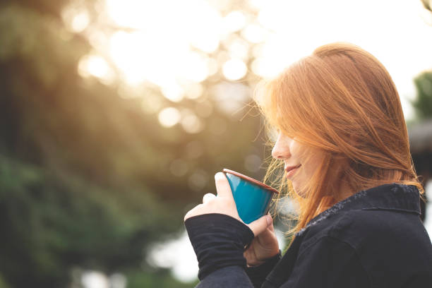 istock young woman drinking coffee in nature 1299422485