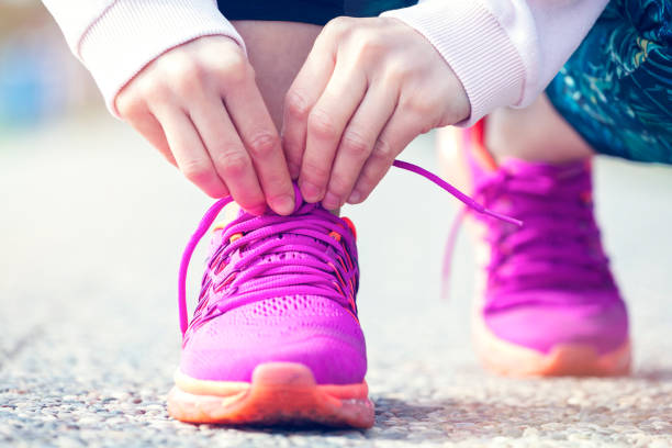istock Young woman runner tying shoelaces 1299425953