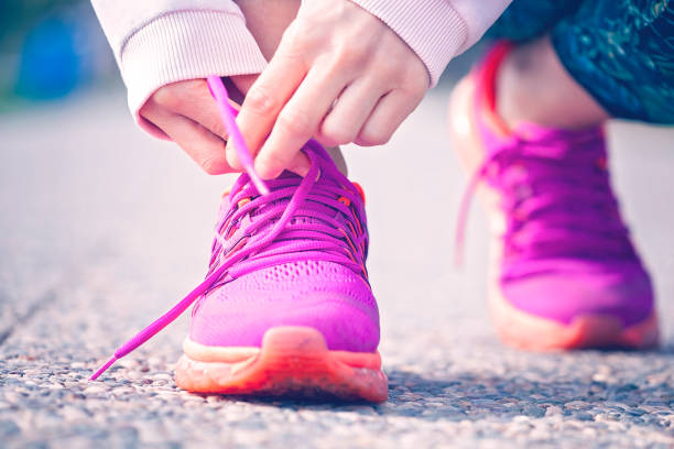 istock Young woman runner tying shoelaces 1299426602