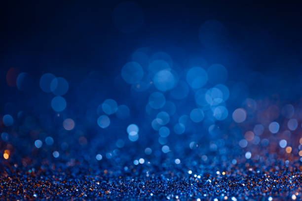 istock Decoration bokeh glitters background, abstract shiny backdrop with circles,modern design overlay with sparkling glimmers. Blue and golden backdrop glittering sparks with blur effect. 1299427051