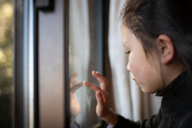 istock Girl touching the window glass 1299429680