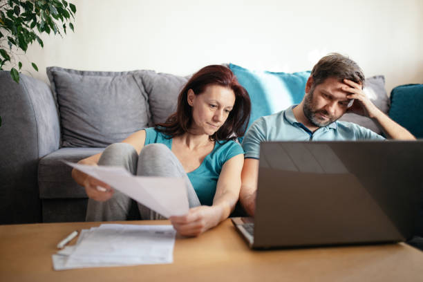 istock Husband and wife looking at bills 1299430533