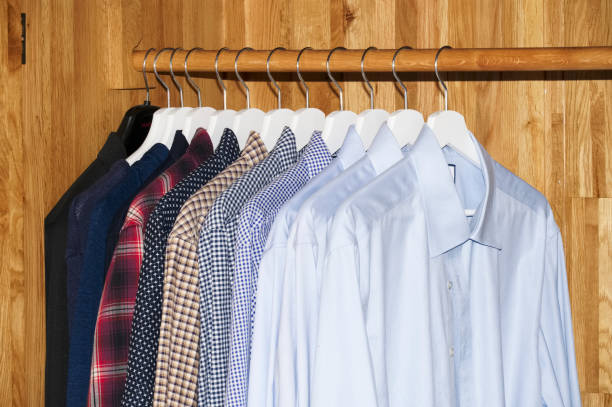istock Clothes hanging on rail in wooden wardrobe close up 1299431685