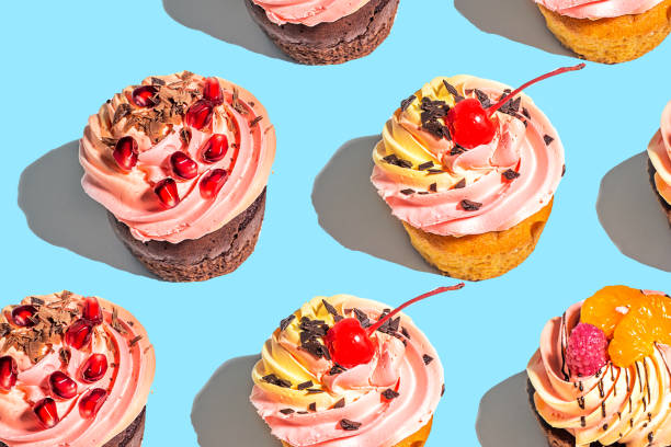 Tasty colorful cupcakes on pink background.