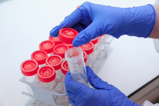 istock Hand with medical glove holding one laboratory test tube from a batch. 1299435652