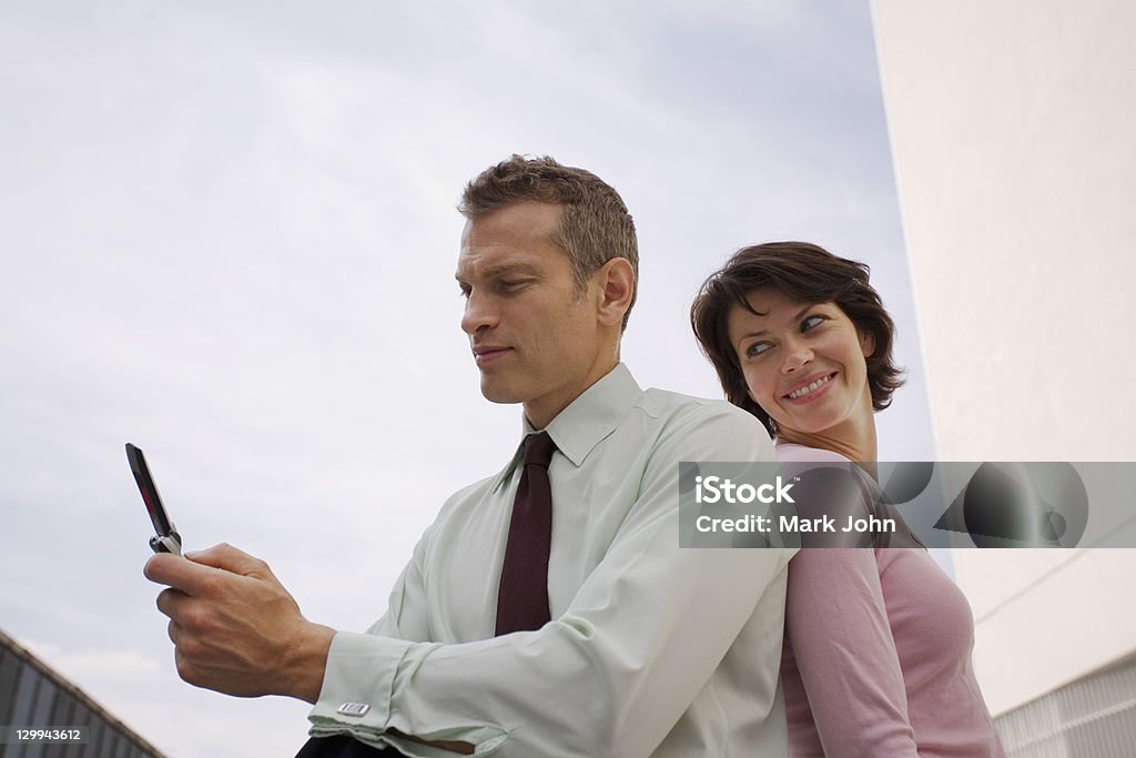Business people sitting outdoors  Back To Back Stock Photo