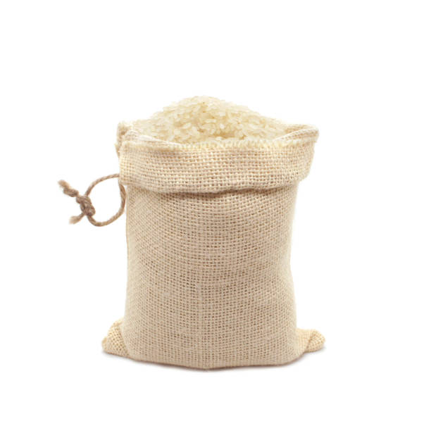 Yellow Rice in burlap bag isolated on white background. Close-up.