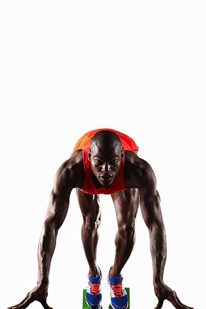 runner crouched en línea de salida - atletismo en pista masculino fotografías e imágenes de stock