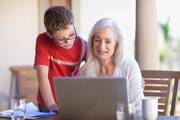 babcia i wnuk, korzystający z laptopa - grandmother reading child grandson zdjęcia i obrazy z banku zdjęć