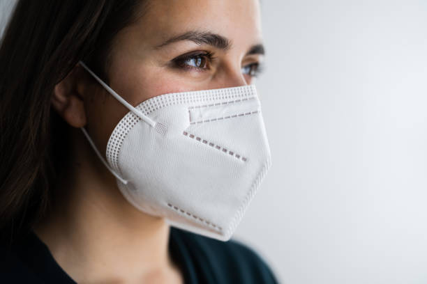 Receptionist Woman In Medical Face Mask Receptionist Woman In Medical FFP2 Face Mask kn95 face mask photos stock pictures, royalty-free photos & images
