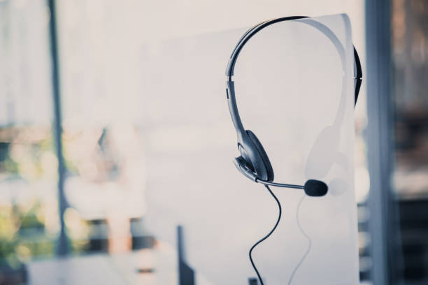 istock Communication support, call center and customer service help desk. VOIP headset on telephone keyboard. 1299443034