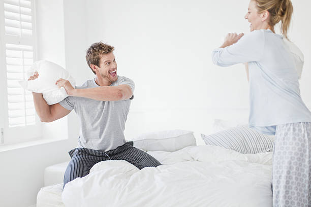 par tener una lucha con almohada del dormitorio - bed couple pillow fight men fotografías e imágenes de stock