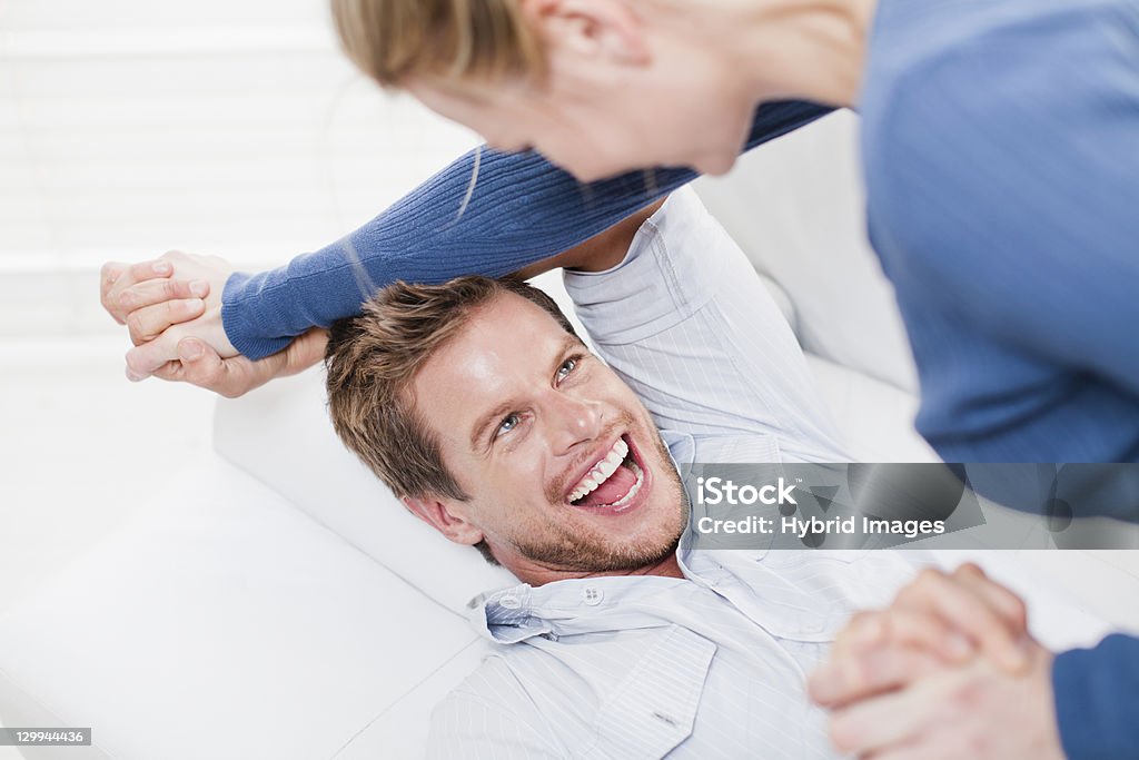 Couple playing together on couch  25-29 Years Stock Photo