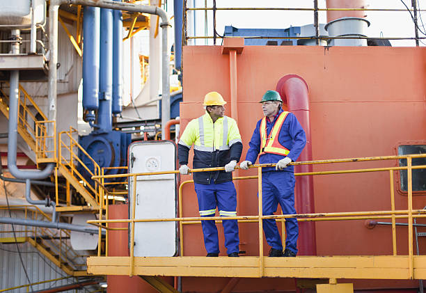 рабочие разговаривающие на нефтяной платформы - нефтяник стоковые фото и изображения