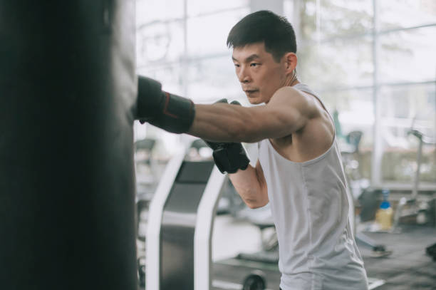 asiatische chinesische männliche athlet üben boxen im fitness-studio auf routine - body building men flexing muscles male stock-fotos und bilder