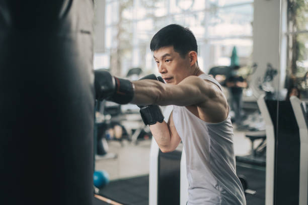 istock asian chinese male athlete practicing boxing in gym on routine 1299445859