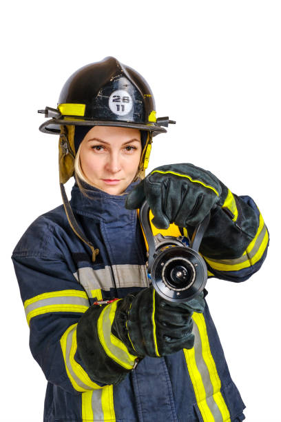 istock Woman in uniform, hardhat of firefighter opens valve on fire hose nozzle 1299446105