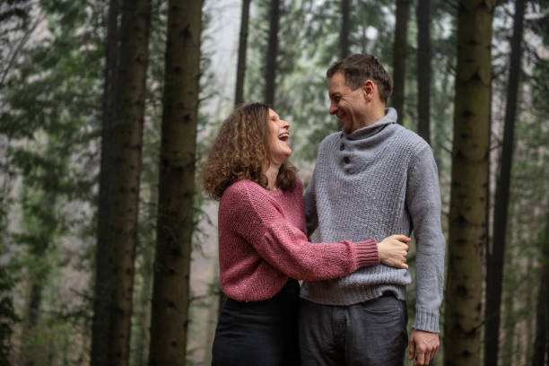istock Smiling Couple posing in the Spruce Forest 1299446917