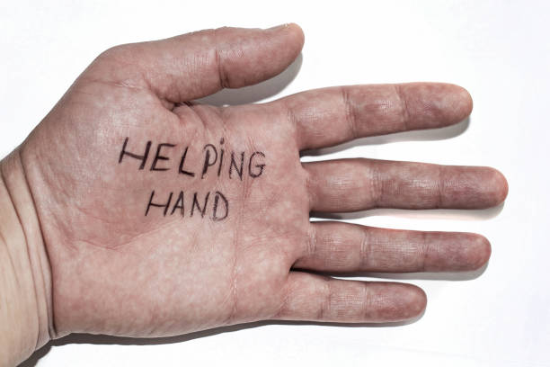 Pointing to the word help with the finger, german language, giving support and charity
