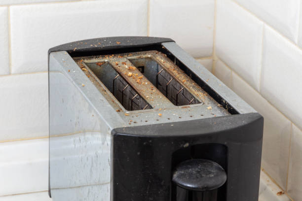 schmutziger toaster mit verbrannten krümeln - getoastet stock-fotos und bilder