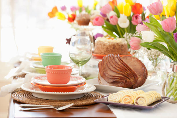 Easter Ham Dining Table Easter ham brunch. Dining Table with a Centerpiece of Fresh Colorful Tulips carrot cake day stock pictures, royalty-free photos & images