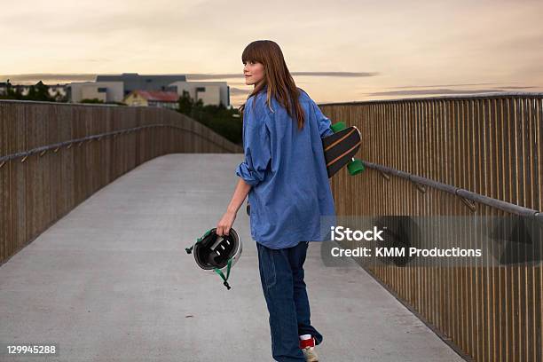 Girl Carrying Skateboard On Walkway Stock Photo - Download Image Now - 14-15 Years, Boardwalk, Brown Hair