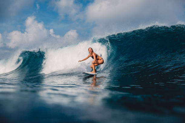 surfista en la tabla de surf en la ola de barril. mujer deportiva en el océano durante el surf. - bikini surfboard women surfing fotografías e imágenes de stock