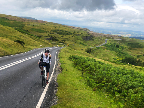 Female cyclist riding up Llangynidr Mountain one of the top UK cycling climbs.
