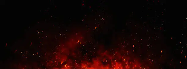 Photo of Fire embers particles over black background.