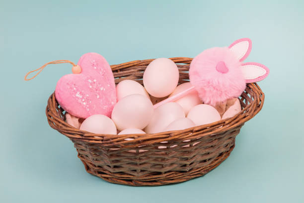 istock Easter. White eggs in a basket on a uniform blue background. Place for text. 1299454573