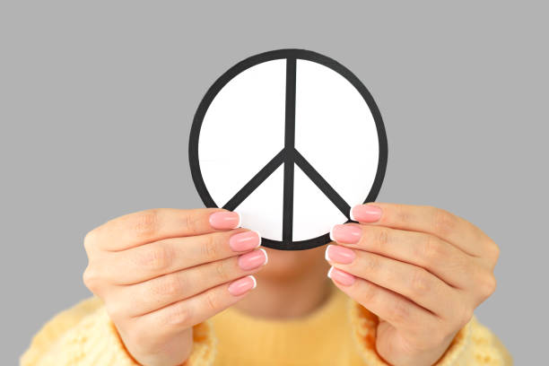 Woman holding paper peace symbol close-up. Freedom, love and peace concept