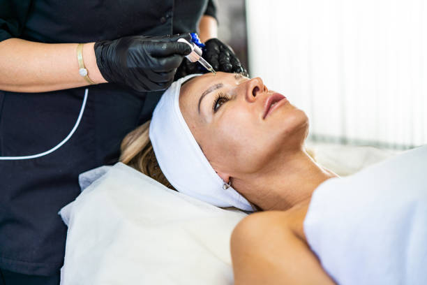 istock Beautician applying face oil on woman face 1299457584