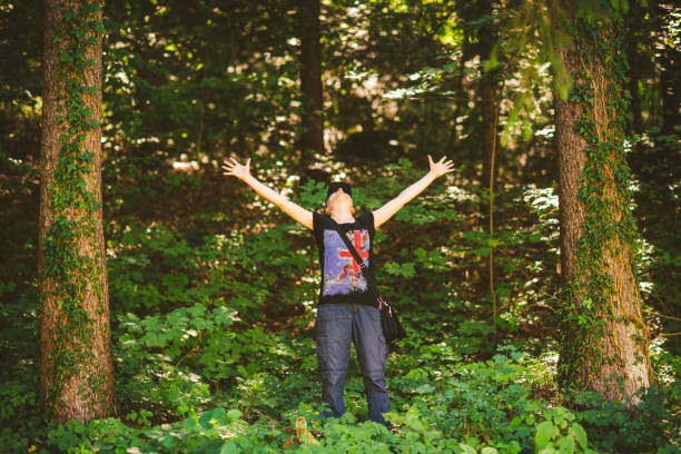 istock Young woman enjoying nature in green forest 1299458770